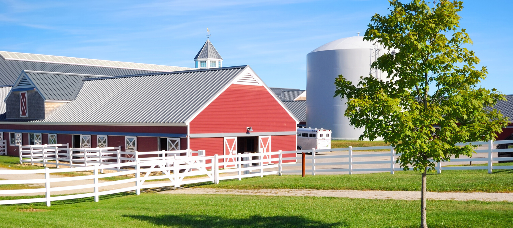 A farm surrounded by a white fence.